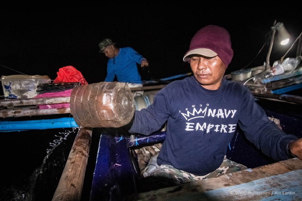 edgardo empties water from the hold of the fishing boat