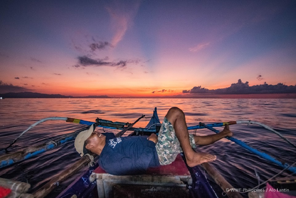 in-the-dim-light-of-sunrise-edgardo lies back across the beams of the fishing boat