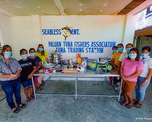 women from the paluan tuna fishers association stand next to the food processing equipment feature image
