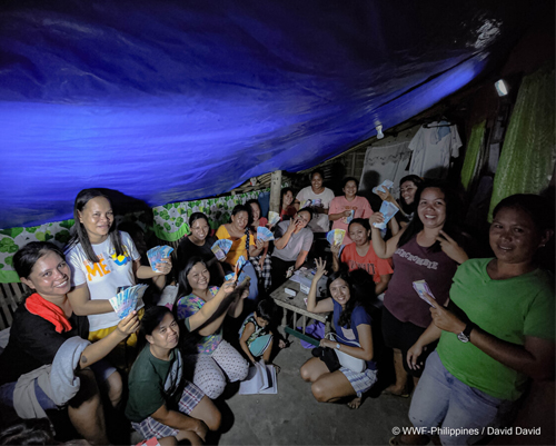 members of a gslc in occidental mindoro huddle under a tent roof as they go through their christmas cashout featured image