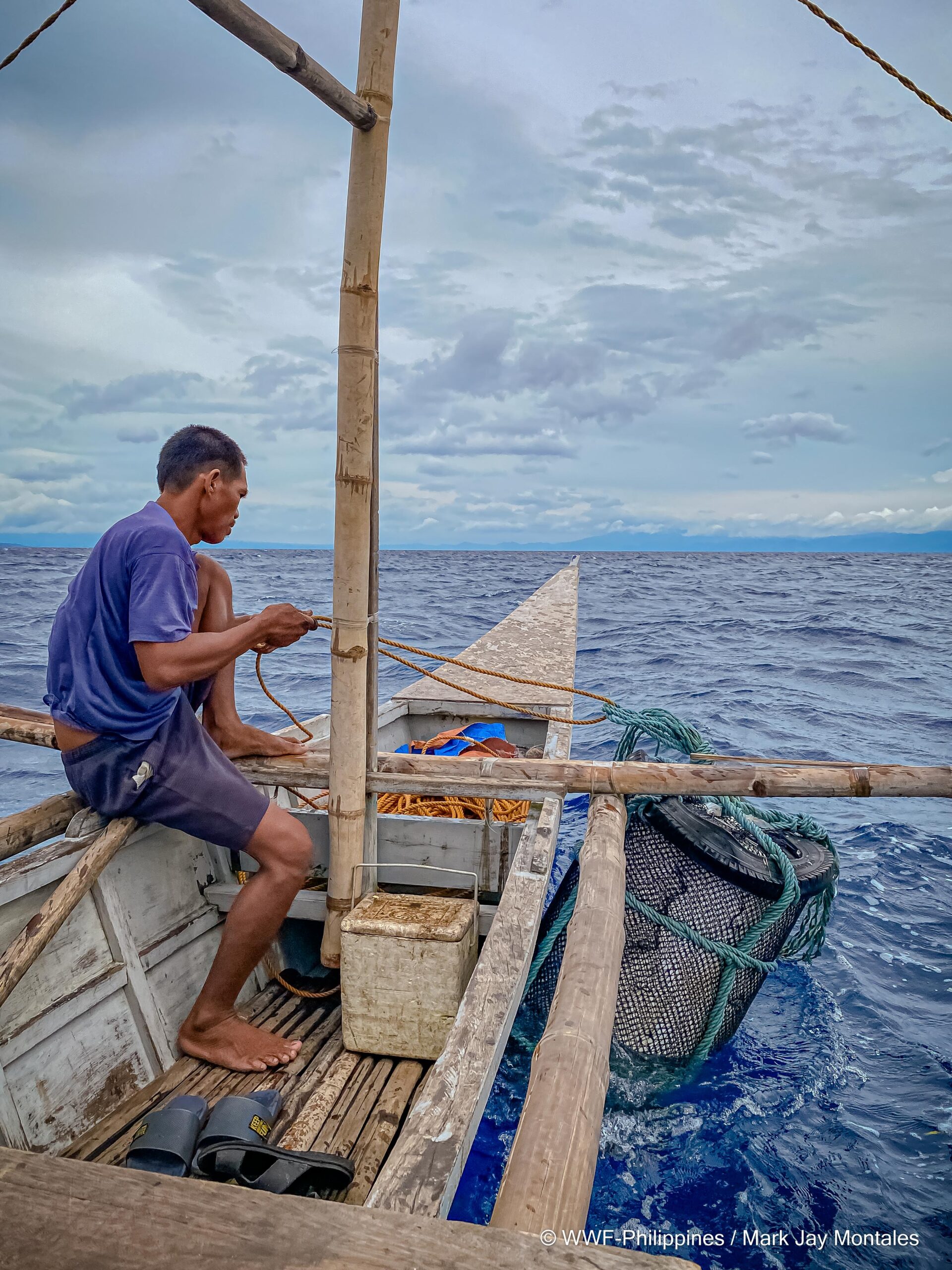 A fisher reels in a FAD. Though FADs make fishing easier, their usage can have negative impacts on marine ecosystems.